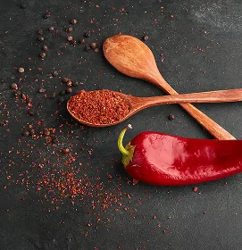Hel rød chili og chilipulver på træskeer